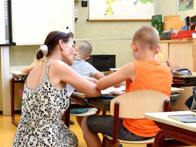 Teacher is helping a young child with school work