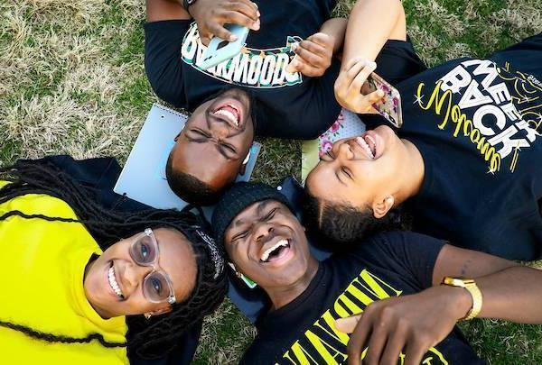 students laying in the grass laughing